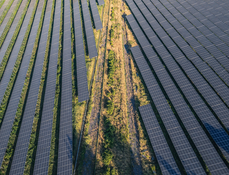 Aerial view of solar photovoltaic panels forming geometric rows at a utility scale solar farm in Le Pouzin Auvergne Rhone Alpes France. Aerial view of solar photovoltaic panels forming geometric rows at a utility scale solar farm in Le Pouzin Auvergne Rhone Alpes France.