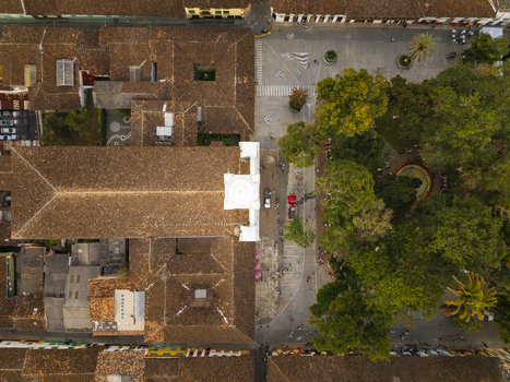 Aerial view of terracotta rooftops meeting lush green trees in the central plaza a vibrant tapestry of urban life Salamina Caldas Colombia. Aerial view of terracotta rooftops meeting lush green trees in the central plaza a vibrant tapestry of urban life Salamina Caldas Colombia.