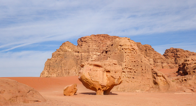 View of the iconic mushroom shaped rock formation in the Wadi Rum Desert surrounded by vast red sand dunes under a clear blue sky in Wadi Rum Village Aqaba Governorate Jordan. View of the iconic mushroom shaped rock formation in the Wadi Rum Desert surrounded by vast red sand dunes under a clear blue sky in Wadi Rum Village Aqaba Governorate Jordan.