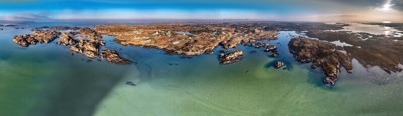 Aerial view of the rugged coastline and rocky islands of Cloughglass surrounded by clear turquoise waters under a bright sky in Cloughglass County Donegal Ireland. Aerial view of the rugged coastline and rocky islands of Cloughglass surrounded by clear turquoise waters under a bright sky in Cloughglass County Donegal Ireland.