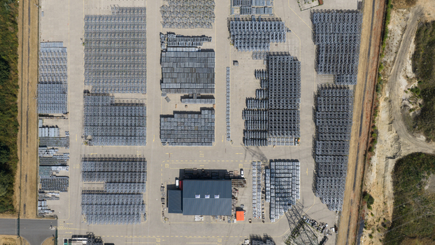 Aerial view of the Amprion GmbH industrial storage yard with rows of metal components and equipment neatly arranged on the paved ground in Herten Nordrhein Westfalen Germany.
