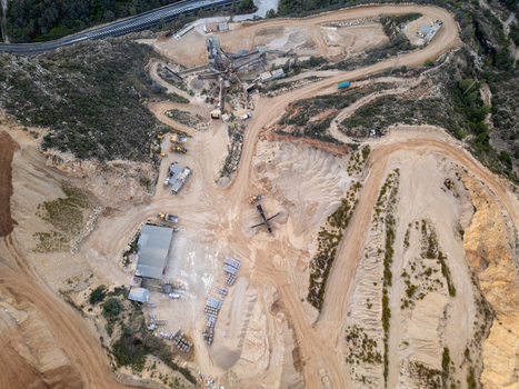 Aerial view of the quarry site in Teulada showing heavy machinery dirt roads and excavated terrain in Teulada Valencian Community Spain.