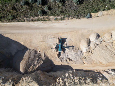 Aerial view of a quarry site with heavy machinery piles of sand and gravel and excavated earth in Teulada Valencian Community Spain.