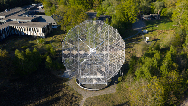 Aerial view of the Radiotelescoop dish structure surrounded by lush green forest and research buildings in Dwingeloo Drenthe Netherlands.
