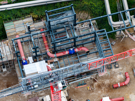 Aerial view of the industrial construction site at the Heizkraftwerk Reuter West power plant featuring steel frameworks large red pipes and crane machinery in Berlin Berlin Germany.
