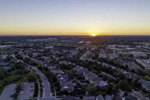 Aerial view of a residential neighborhood with houses trees and roads during a vibrant sunset in Glenview Illinois United States. Aerial view of a residential neighborhood with houses trees and roads during a vibrant sunset in Glenview Illinois United States.