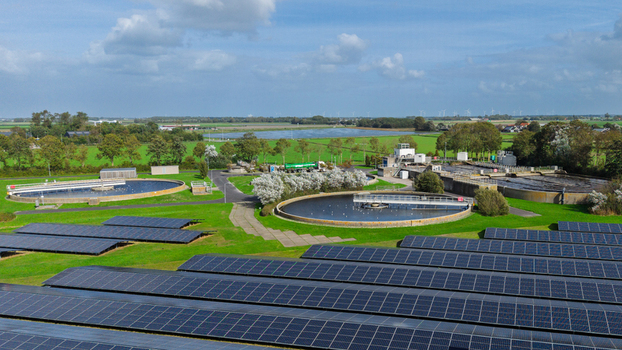 Aerial view of a water treatment plant with circular sedimentation tanks solar panel arrays and green fields in Schagerbrug Noord Holland Netherlands. Aerial view of a water treatment plant with circular sedimentation tanks solar panel arrays and green fields in Schagerbrug Noord Holland Netherlands.