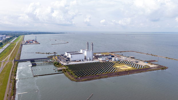 Aerial view of the Maxima power plant with its solar panel array and industrial facilities situated along the coast in Lelystad Flevoland Netherlands. Aerial view of the Maxima power plant with its solar panel array and industrial facilities situated along the coast in Lelystad Flevoland Netherlands.
