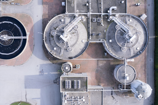 Aerial view of the Waste Water Treatment facility featuring circular sedimentation tanks industrial piping and concrete infrastructure in Richmond British Columbia Canada. Aerial view of the Waste Water Treatment facility featuring circular sedimentation tanks industrial piping and concrete infrastructure in Richmond British Columbia Canada.