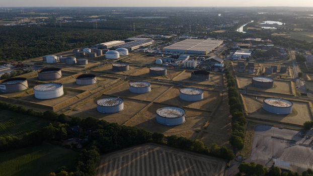 Aerial view of the Tanklager tank farm featuring large industrial storage tanks grassy embankments and warehouse facilities in Hunxe North Rhine Westphalia Germany.