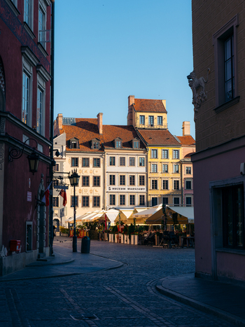 View of the historic colorful buildings and outdoor cafe umbrellas in the Warsaw Old Town square under a clear blue sky in Warsaw Masovian Voivodeship Poland. View of the historic colorful buildings and outdoor cafe umbrellas in the Warsaw Old Town square under a clear blue sky in Warsaw Masovian Voivodeship Poland.