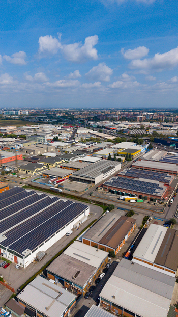 Aerial view of industrial warehouses with solar panels on rooftops roads and surrounding urban landscape in Milan Lombardy Italy. Aerial view of industrial warehouses with solar panels on rooftops roads and surrounding urban landscape in Milan Lombardy Italy.