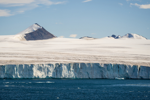 View of the icy coastline and glaciers of Paulet Island with snow covered mountains under a clear blue sky in Antarctica. View of the icy coastline and glaciers of Paulet Island with snow covered mountains under a clear blue sky in Antarctica.