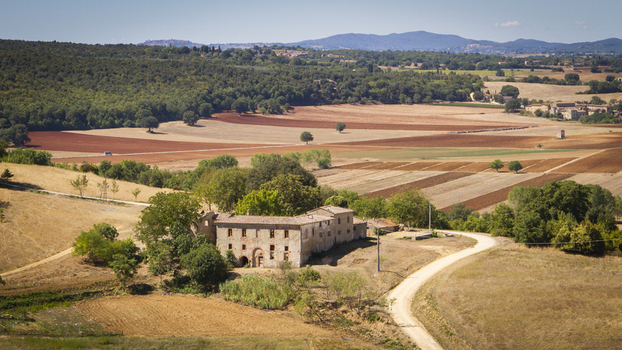 View of rustic stone building with arched entrances sits amidst sun drenched fields a tapestry of ochre and umber under a boundless sky Monteriggioni Tuscany Italy. View of rustic stone building with arched entrances sits amidst sun drenched fields a tapestry of ochre and umber under a boundless sky Monteriggioni Tuscany Italy.