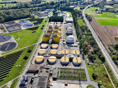 Aerial view of the Impianto depurazione water treatment plant with circular tanks yellow digesters and solar panels in Castiglione Torinese Piedmont Italy.