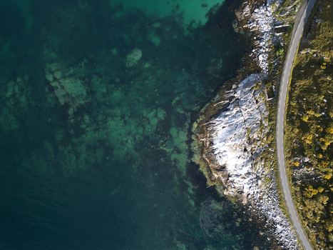 Aerial view of the rugged coastline at Vik Strand with turquoise water rocky shores and a winding road along the cliffs near Leknes Nordland Norway. Aerial view of the rugged coastline at Vik Strand with turquoise water rocky shores and a winding road along the cliffs near Leknes Nordland Norway.