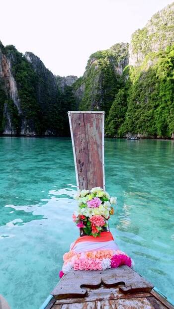 View of a longtail boat and limestone karsts Thailand.