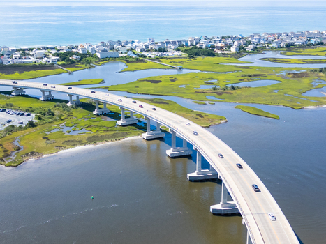 Aerial view of North Topsail Bridge spanning the marshlands and coastal waters with cars driving across the structure in North Topsail Beach North Carolina United States.