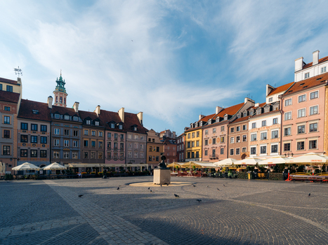 View of Warsaw Old Town Market Place with colorful historic buildings cobblestone square and outdoor cafe umbrellas in Warsaw Masovian Voivodeship Poland. View of Warsaw Old Town Market Place with colorful historic buildings cobblestone square and outdoor cafe umbrellas in Warsaw Masovian Voivodeship Poland.