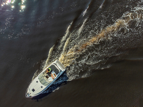 Aerial view of a boat slicing through the dark waters leaving a frothy white wake in its path a dance of power and serenity Eemdijk Utrecht Netherlands.