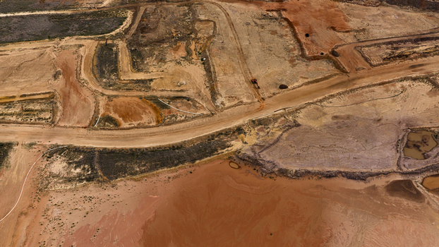 Aerial view of industrial earthworks and textured terrain at a salt production site with vibrant mineral deposits and tracks in Kalbarri Western Australia Australia. Aerial view of industrial earthworks and textured terrain at a salt production site with vibrant mineral deposits and tracks in Kalbarri Western Australia Australia.