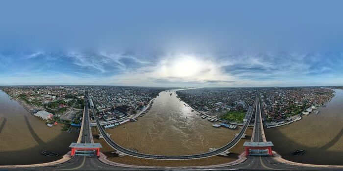 Aerial view of the Ampera Bridge spanning the Musi River with the urban landscape of Palembang in the background in Kecamatan Seberang Ulu I Sumatera Selatan Indonesia. Aerial view of the Ampera Bridge spanning the Musi River with the urban landscape of Palembang in the background in Kecamatan Seberang Ulu I Sumatera Selatan Indonesia.