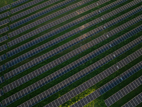 Aerial view of rows of solar panels arranged in a geometric pattern over green grass in a solar farm Augusta Sicily Italy. Aerial view of rows of solar panels arranged in a geometric pattern over green grass in a solar farm Augusta Sicily Italy.