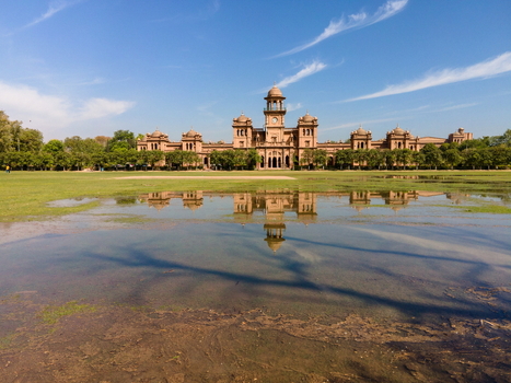 Aerial view of Islamia College University Peshawar featuring its historic architecture reflected in a flooded lawn under a clear blue sky in Peshawar Khyber Pakhtunkhwa Pakistan. Aerial view of Islamia College University Peshawar featuring its historic architecture reflected in a flooded lawn under a clear blue sky in Peshawar Khyber Pakhtunkhwa Pakistan.