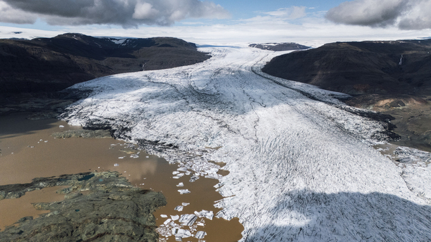 Aerial view of glacial ice flowing into a silt filled lake under a cloudy sky Hoffellsjokull Iceland. Aerial view of glacial ice flowing into a silt filled lake under a cloudy sky Hoffellsjokull Iceland.
