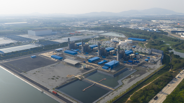 Aerial view of the Gulf Pluak Daeng Power Plant featuring blue industrial buildings tall smokestacks and water reservoirs in Map Yang Phon Rayong Thailand. Aerial view of the Gulf Pluak Daeng Power Plant featuring blue industrial buildings tall smokestacks and water reservoirs in Map Yang Phon Rayong Thailand.