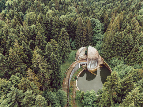 Aerial view of the Korcanica Memorial Zone monument with its split sphere and pool nestled in a dense pine forest in Sanski Most Federation of Bosnia Bosnia and Herzegovina. Aerial view of the Korcanica Memorial Zone monument with its split sphere and pool nestled in a dense pine forest in Sanski Most Federation of Bosnia Bosnia and Herzegovina.