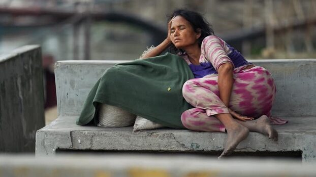 View of a woman resting on a concrete ledge in Aminbazar Bangladesh. View of a woman resting on a concrete ledge in Aminbazar Bangladesh.