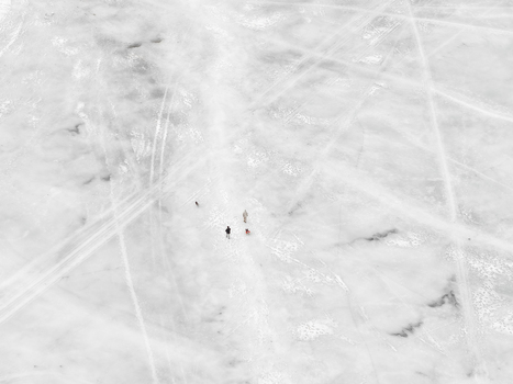 Aerial view of people walking on the frozen surface of Lake Galve with visible tracks in the snow and ice in Trakai Vilnius County Lithuania. Aerial view of people walking on the frozen surface of Lake Galve with visible tracks in the snow and ice in Trakai Vilnius County Lithuania.