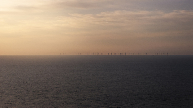 Aerial view of wind turbines in the Atlantic Ocean during a golden sunset off the coast of Plevenon Brittany France. Aerial view of wind turbines in the Atlantic Ocean during a golden sunset off the coast of Plevenon Brittany France.