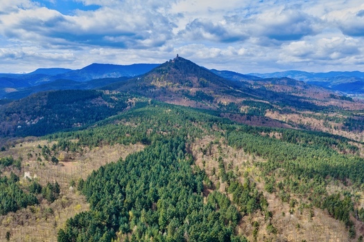 Aerial view of Haut Koenigsbourg Castle perched atop a verdant rugged mountain surrounded by a tapestry of forests and hills Kintzheim Grand Est France.