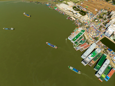 Aerial view of a bustling port where boats gather near the shoreline with a mix of vibrant and earthy tones Charmonai Barisal Division Bangladesh. Aerial view of a bustling port where boats gather near the shoreline with a mix of vibrant and earthy tones Charmonai Barisal Division Bangladesh.