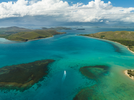 Aerial view of turquoise waters embrace the land with open arms revealing the intricate coastal patterns and the distant hills Noumea New Caledonia. Aerial view of turquoise waters embrace the land with open arms revealing the intricate coastal patterns and the distant hills Noumea New Caledonia.