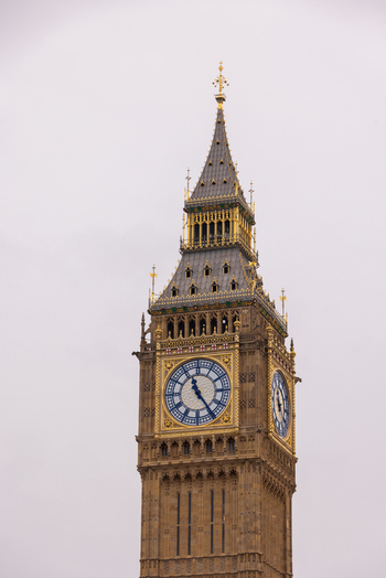London United Kingdom 12 May 2025 View of the iconic Elizabeth Tower and Big Ben clock face with its ornate gothic architecture and golden details against an overcast sky.