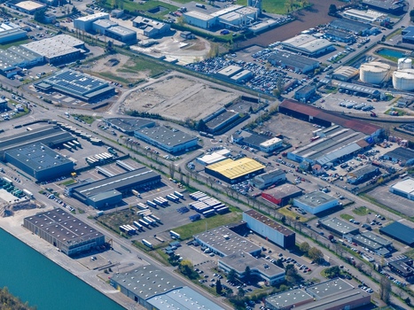 Aerial view of an industrial zone with varied rooftops and roads reflecting the sunlight creating a tapestry of textures and tones Sausheim Grand Est France.