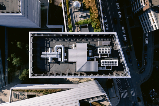 Aerial view of a modern building rooftop featuring industrial ventilation systems metallic ducts and cooling units situated in the urban landscape of Vilnius Vilnius County Lithuania.