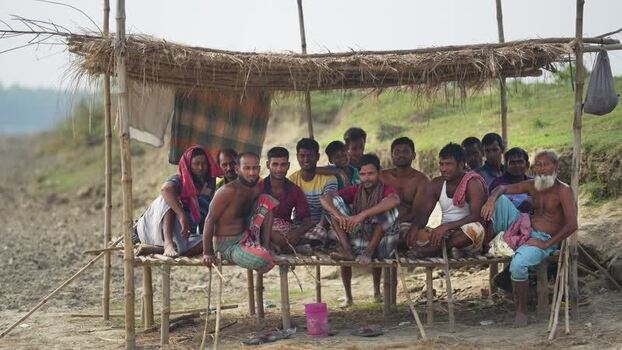 View of a group of men sitting under a straw shelter Bangladesh. View of a group of men sitting under a straw shelter Bangladesh.