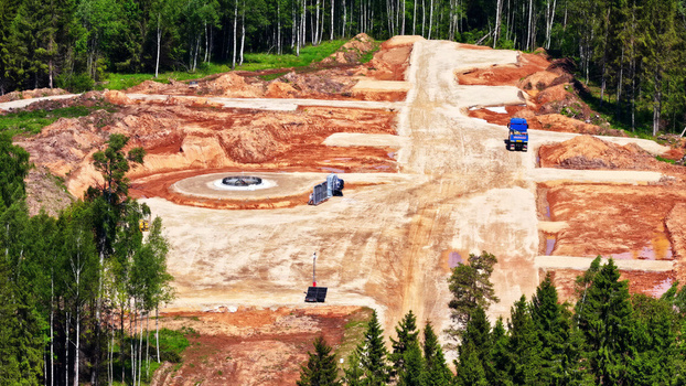 Aerial view of a wind turbine foundation under construction in a cleared forest area with a truck and heavy machinery in Latvia. Aerial view of a wind turbine foundation under construction in a cleared forest area with a truck and heavy machinery in Latvia.