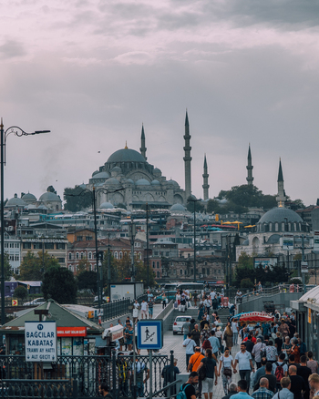 Istanbul Turkiye 04 October 2019 View of the bustling Galata Bridge teeming with life framed against the majestic silhouette of the S&uuml;leymaniye Mosque under a muted sky.