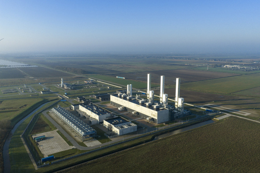Aerial view of the nitrogen plant with tall white chimneys and industrial structures surrounded by flat agricultural fields in Zuidbroek Groningen Netherlands. Aerial view of the nitrogen plant with tall white chimneys and industrial structures surrounded by flat agricultural fields in Zuidbroek Groningen Netherlands.