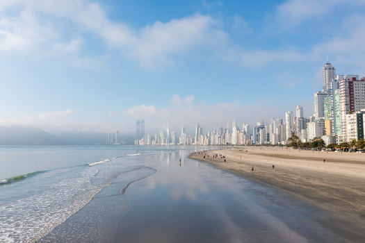 Aerial view of the modern skyscraper skyline reflecting on the wet sand of Central Beach with people walking along the shore in Balneario Camboriu State of Santa Catarina Brazil. Aerial view of the modern skyscraper skyline reflecting on the wet sand of Central Beach with people walking along the shore in Balneario Camboriu State of Santa Catarina Brazil.
