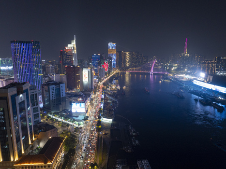 Aerial view of the illuminated Ho Chi Minh City skyline at night featuring the Saigon River busy city streets and glowing skyscrapers Ho Chi Minh City Ho Chi Minh Vietnam. Aerial view of the illuminated Ho Chi Minh City skyline at night featuring the Saigon River busy city streets and glowing skyscrapers Ho Chi Minh City Ho Chi Minh Vietnam.