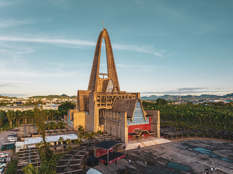 Aerial view of Basilica Nuestra Senora De La Altagracia with its iconic tall concrete arch surrounded by palm trees and paved grounds in Higuey La Altagracia Provinc Dominican Republic. Aerial view of Basilica Nuestra Senora De La Altagracia with its iconic tall concrete arch surrounded by palm trees and paved grounds in Higuey La Altagracia Provinc Dominican Republic.