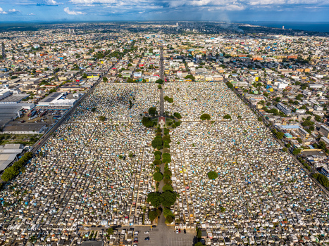 Aerial view of Maximo Gomez National Cemetery with its dense grid of tombs and central tree lined path surrounded by the urban landscape of Santo Domingo Distrito Nacional Dominican Republic. Aerial view of Maximo Gomez National Cemetery with its dense grid of tombs and central tree lined path surrounded by the urban landscape of Santo Domingo Distrito Nacional Dominican Republic.