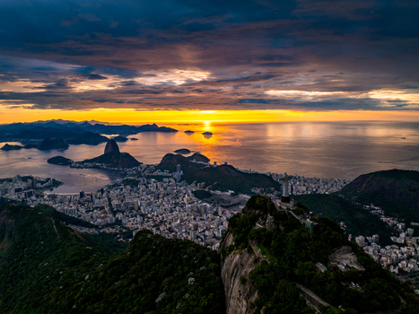 Rio de Janeiro Brazil 01 February 2025 Aerial view of Christ the Redeemer statue overlooking the city Guanabara Bay and Sugarloaf Mountain at sunset with golden light.