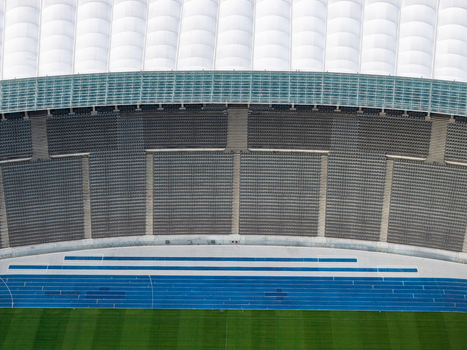 Berlin Germany 26 September 2026 Aerial view of Olympiastadion Berlin showing the blue running track green grass field and rows of stadium seating under the white roof structure.